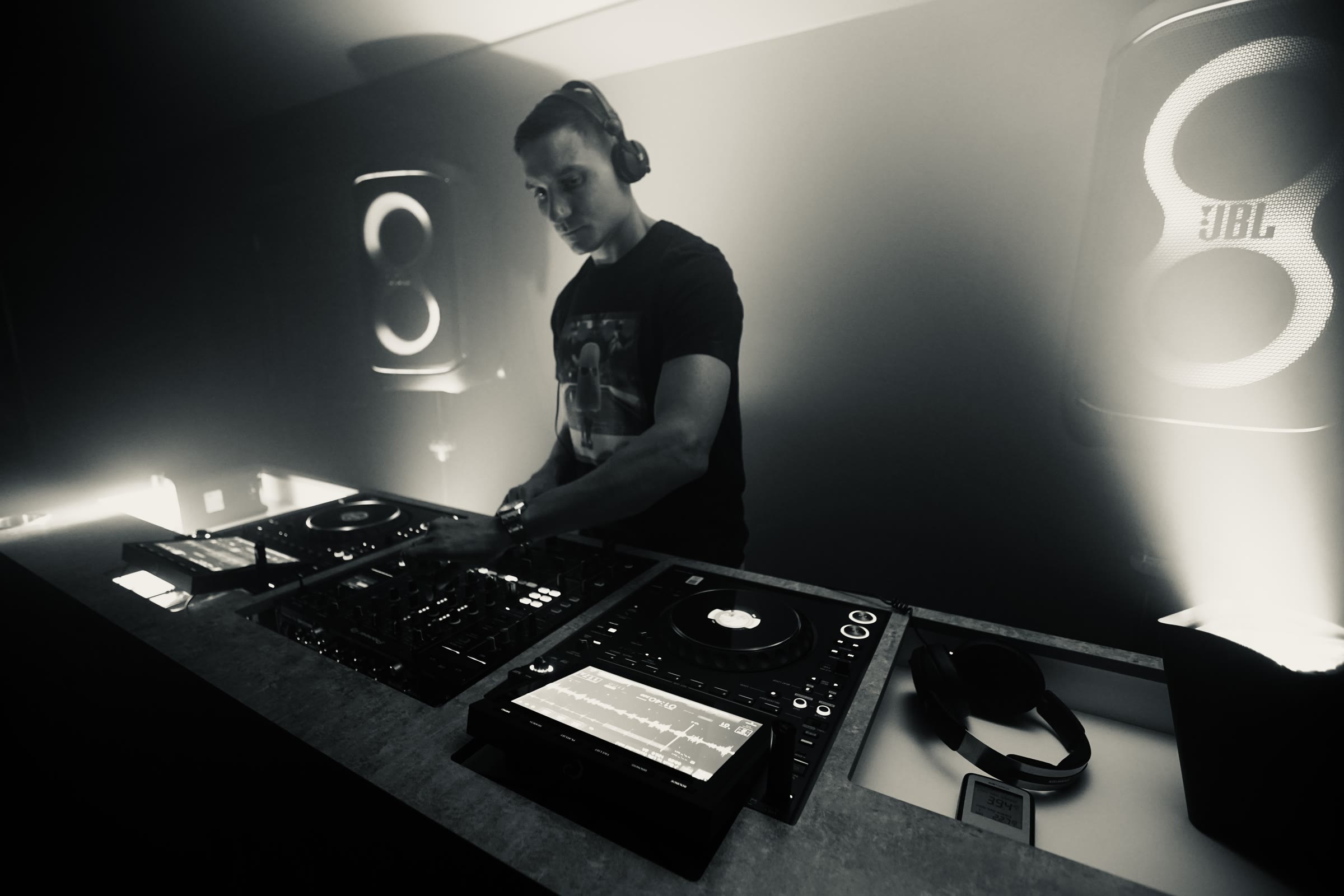 DJ Bolus performing behind the decks in atmospheric black and white